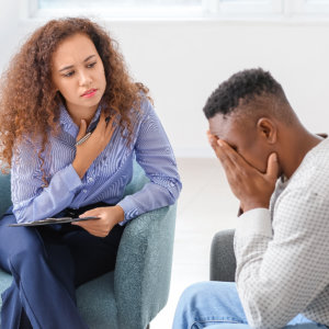 Psychologist working with African-American man in office