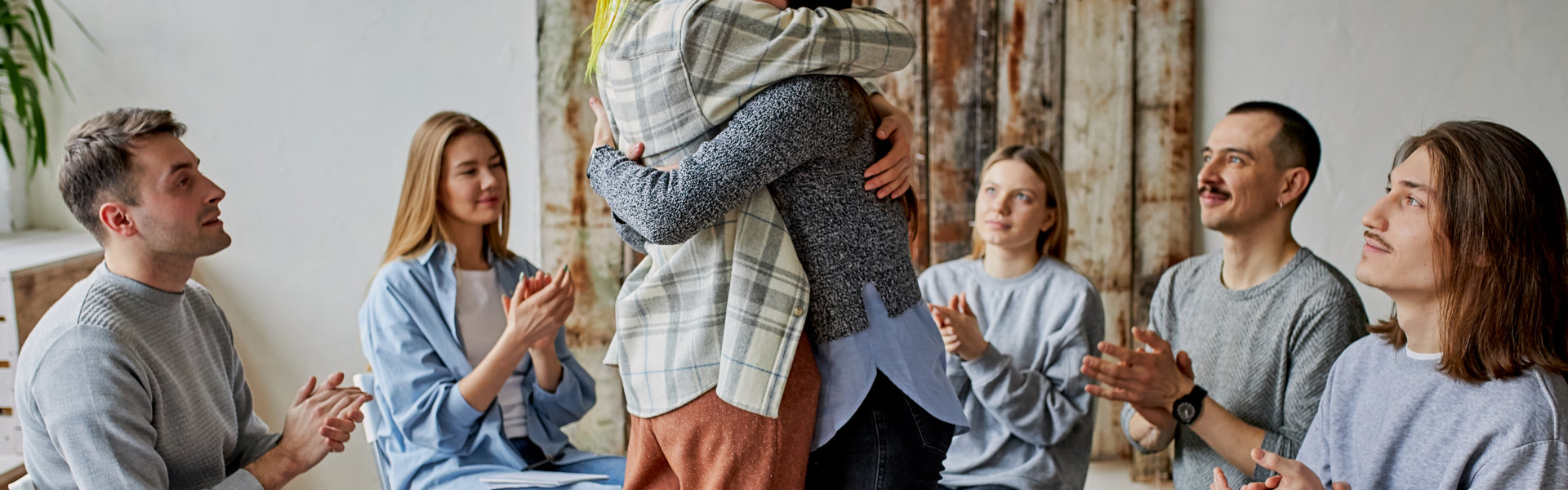 group of people sitting and two woman hugging each other